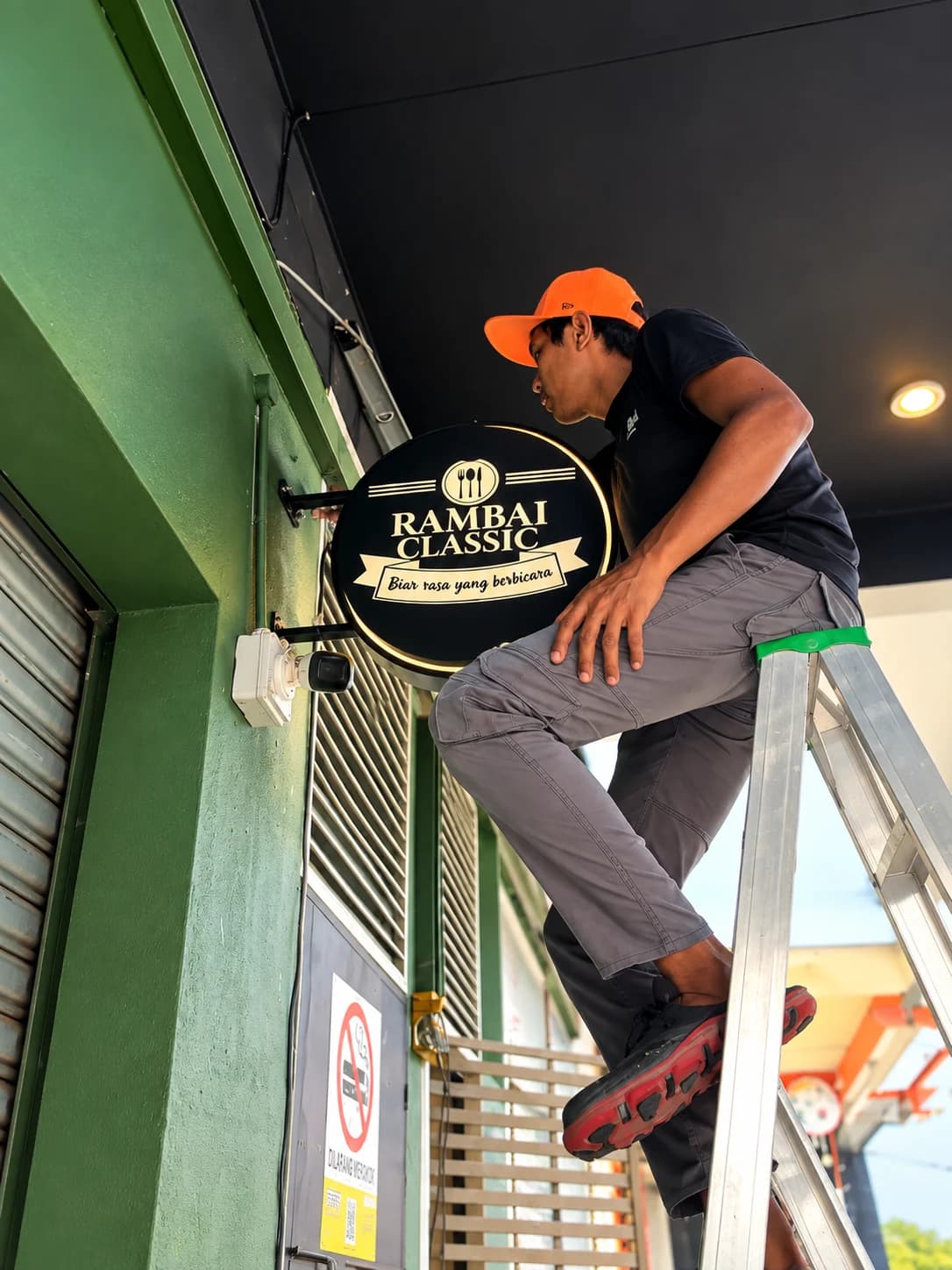 Pasukan Xworm memasang signage Rambai Classic di premis